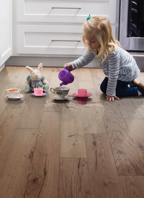 Little girl pouring water on hardwood floor | Carpets Of Dalton