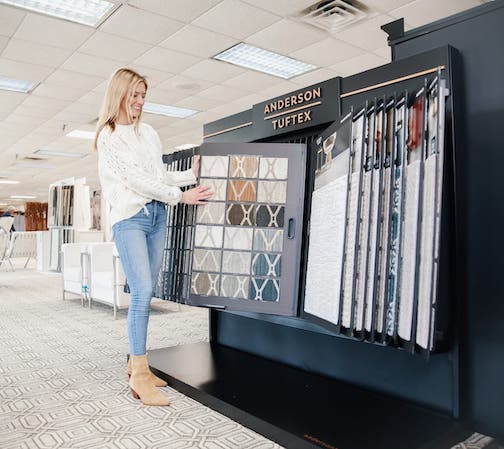 Sales professional showing customer Anderson Tuftex carpet display | Carpets Of Dalton