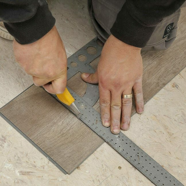 LVP installer cutting tile before installation